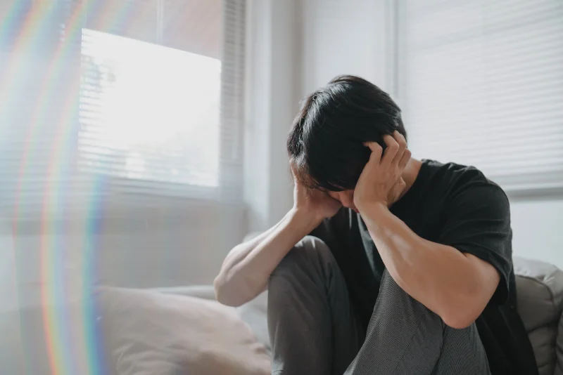 Man sitting with his head in his hands, feeling overwhelmed