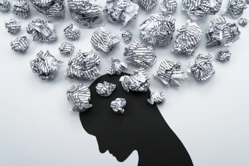 Silhouette of a head surrounded by racing, cluttered thoughts