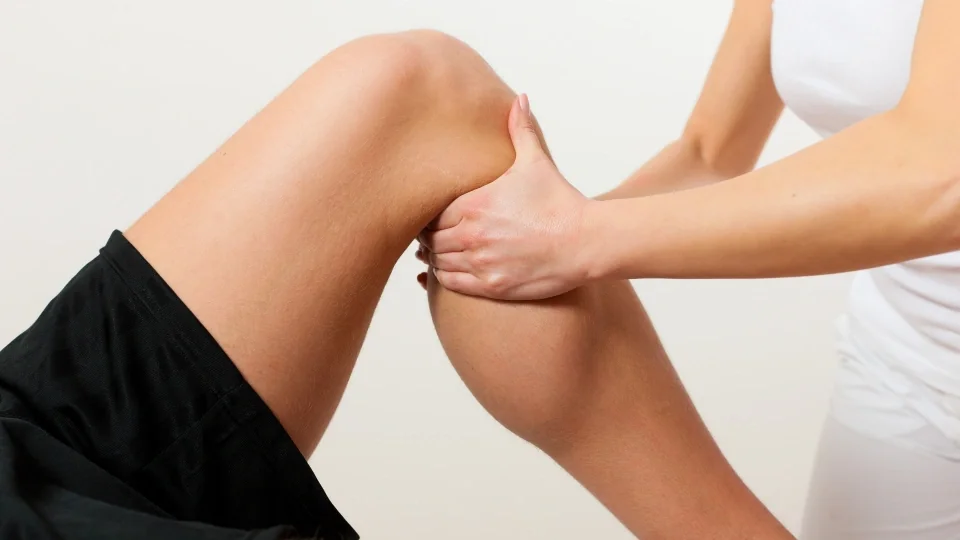 Physiotherapist massaging a patient's knee