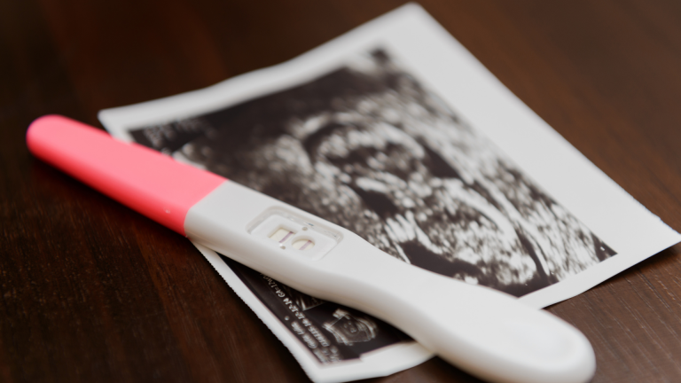 Pregnancy test resting on an ultrasound photograph