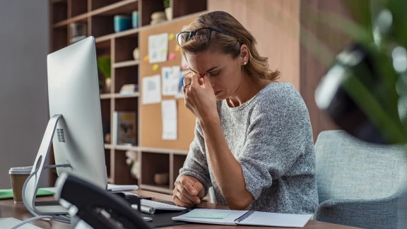 Woman overwhelmed by stress at her desk